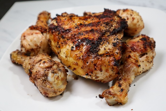 Grilled bone in chicken sitting on a plate
