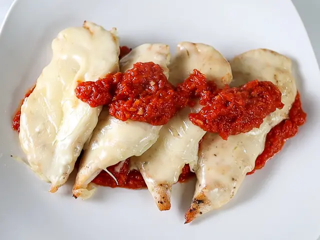 preparing the chicken parmesan on a plate