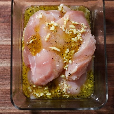 chicken marinating in a dish