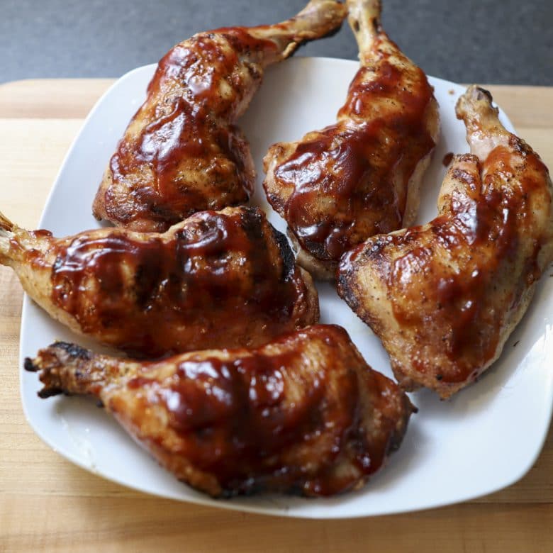 chicken leg quarters resting on a plate
