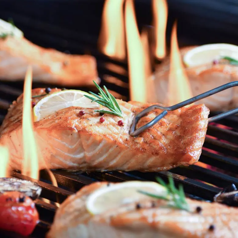 Grilled salmon on a grill with flames
